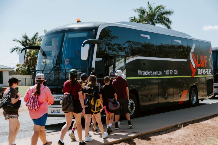 Teenagers on a school trip line up to get back onto the L&F Transfers luxury coach during a private charter trip.